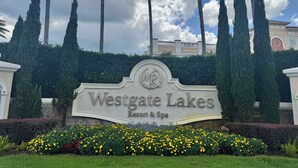 A sign for Westgate Lakes Resort & Spa surrounded by tall cypress trees and a landscaped garden. - Apartment in Orlando, near the theme parks. (Orlando)