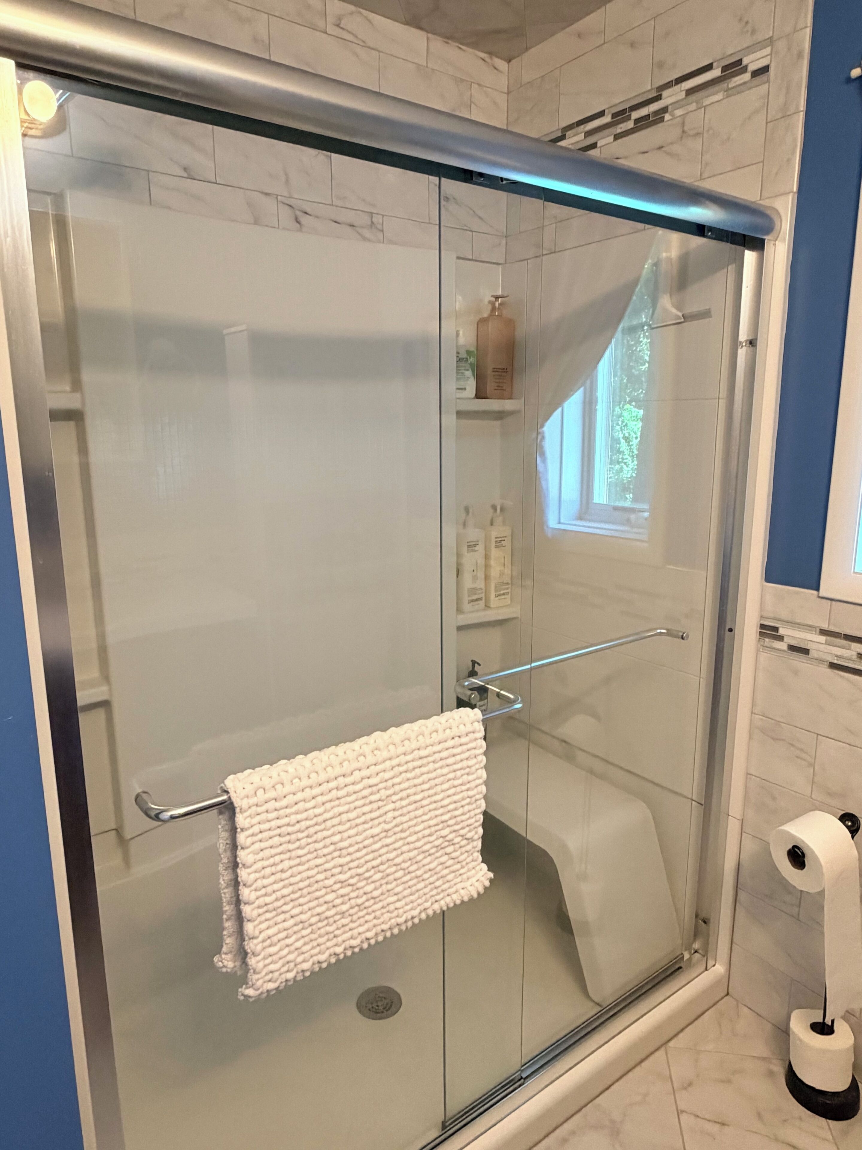 Een douche, handdoeken, zeep, toiletpapier