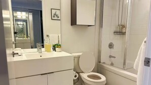 Ein modernes Badezimmer mit Toilette, Waschbecken und Duschbereich.