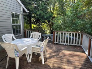 A wooden deck with a table and chairs, surrounded by a railing. - Bright and comfortable home (Portland)