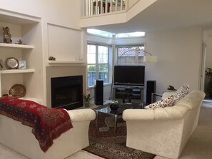 A living room with a fireplace, a TV, and two white sofas. - Bright and comfortable home (Portland)