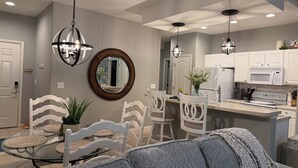 A modern kitchen with white cabinets, a central island, and pendant lighting. - Beautiful 3-bedroom Condo with a view for days in Lake Ozark, MO (Lake Ozark)