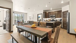 A modern kitchen with dark wooden cabinets, a stainless steel refrigerator, and a built-in microwave. - Hot Tubs | Near Ski Resort & Restaurants (Keystone)