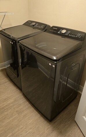 A black front-loading washer and dryer unit with a control panel on top.