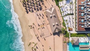An aerial view of a resort with a beach, a pool area, and a building with multiple balconies. - Finest Punta Cana (Punta Cana)