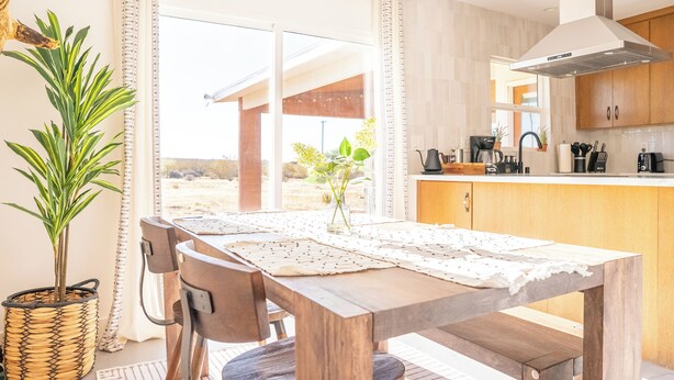 A modern kitchen with wooden cabinets, a stainless steel range hood, and a large window. - Private 5-Acre Joshua Tree Desert Escape - Hot Tub, Fire Pit & Mountain Views (Landers)