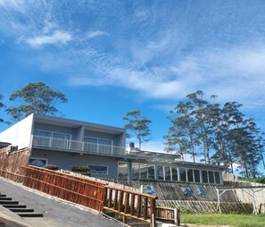 A modern two-story building with a balcony, a staircase, and a wooden fence. - Cozzy Villa Lashyra Aulia Pangalengan (bandung)
