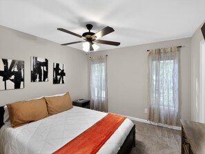 A bedroom with a bed, ceiling fan, artwork, and curtains. - Smyrna Townhome: 2 Queens, Patio, 13 Min to The Battery (Smyrna)
