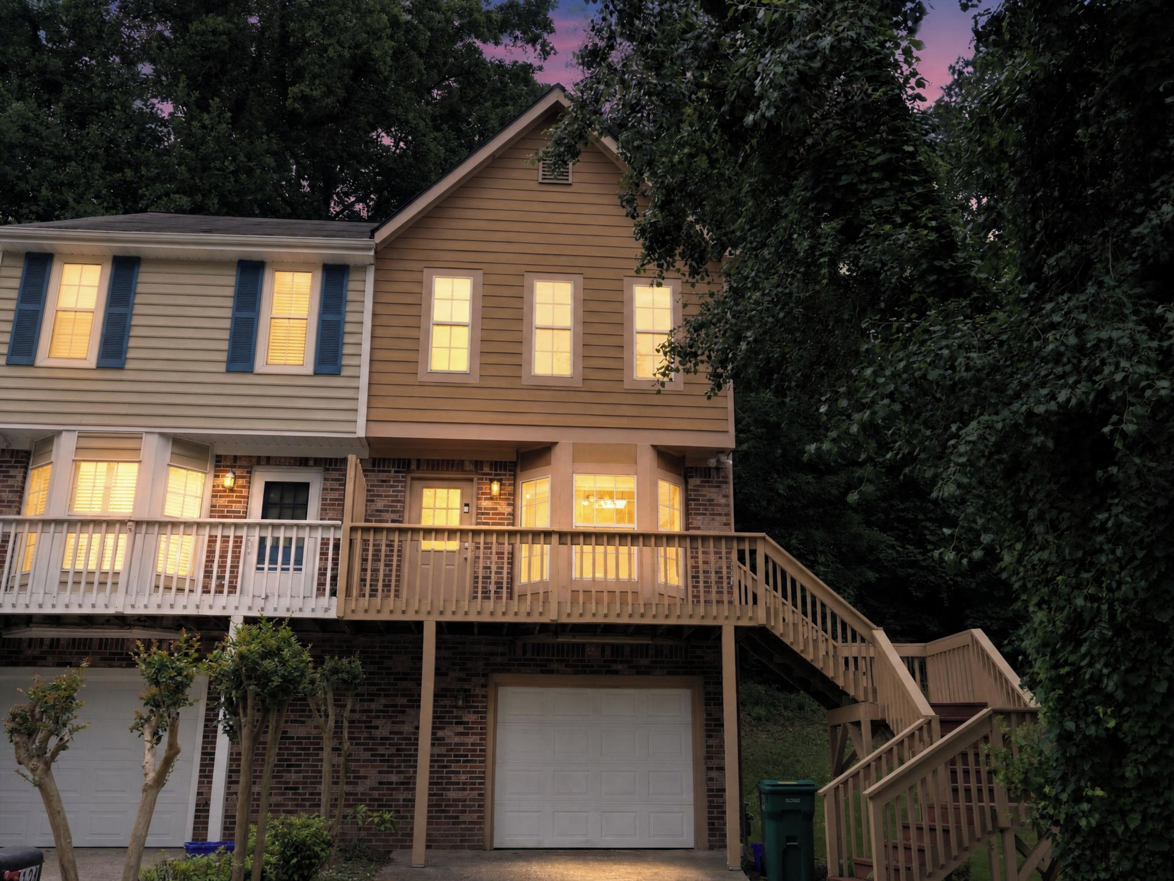 A two-story house with a balcony, a garage, and a staircase leading to the second floor.