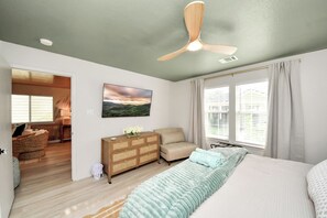 A bedroom with a bed, a dresser, a chair, a ceiling fan, and a window with curtains. - Boutique Stay | Prvt Lounge, Arcade, Firepit | 15m IAH (Houston)