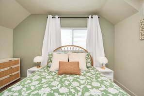 A bedroom with a bed, nightstands, a dresser, and a window with curtains. - Boutique Stay | Prvt Lounge, Arcade, Firepit | 15m IAH (Houston)