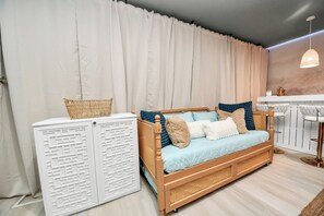 A room with a wooden sofa, white cabinets, and a bar area. - Boutique Stay | Prvt Lounge, Arcade, Firepit | 15m IAH (Houston)