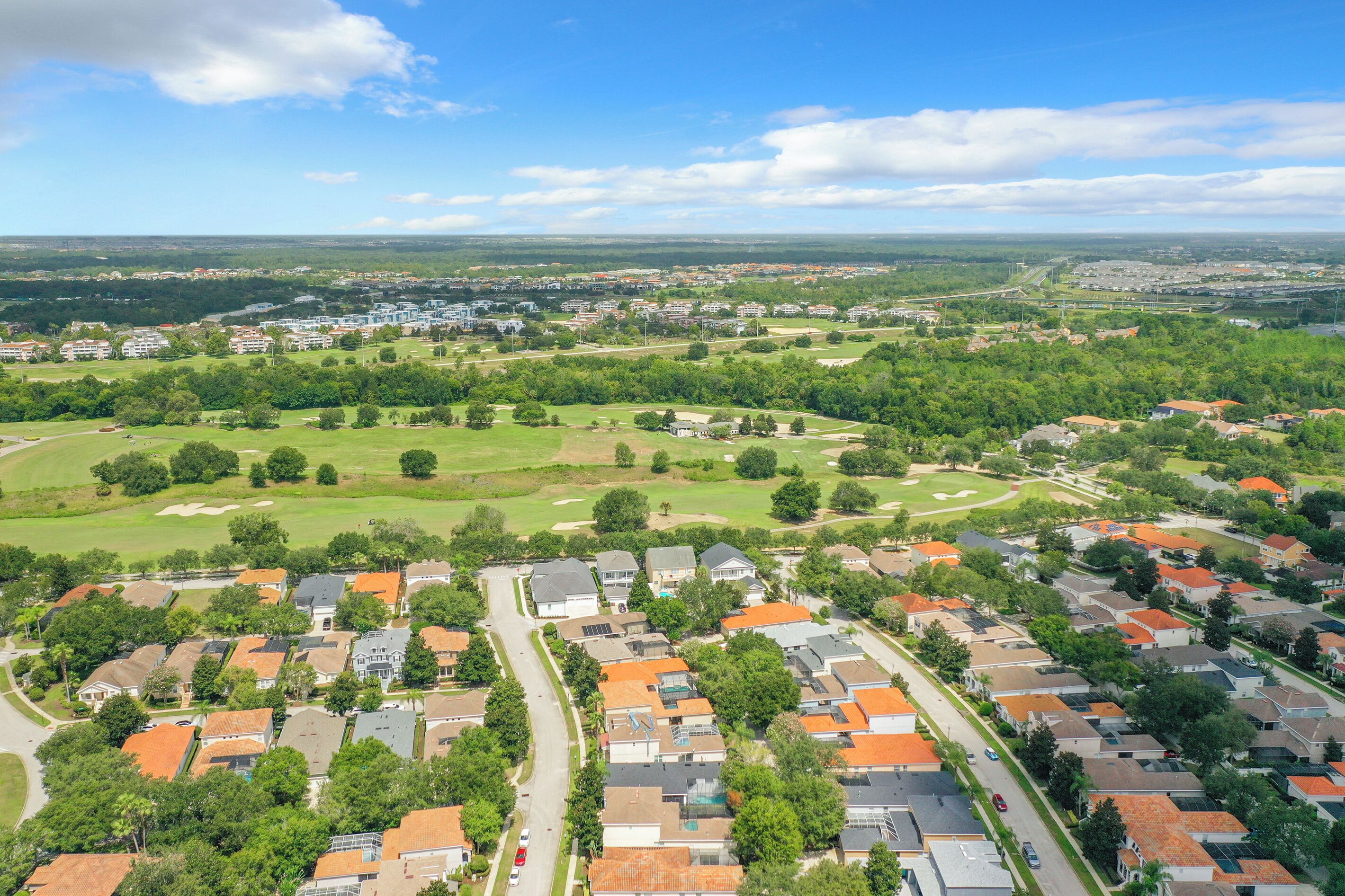 Vista aérea de una zona residencial con casas, caminos y áreas verdes.