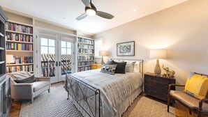 Une chambre à coucher avec un lit, des étagères, un bureau et une chaise.