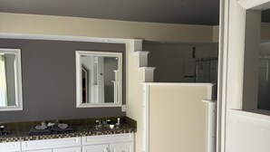 A modern bathroom with a double sink vanity, a mirror, and a shower area. - Wonderful 3 bedroom house (Scott)