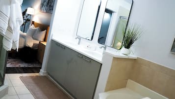 Un baño moderno con bañera, lavamanos y espejo.