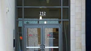 Ein Gebäudeeingang mit Glastür, der Schriftzug '232' darüber und 'ATL OFTS ATLANTIC STATION' auf dem Glas.