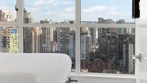 Una habitación con un amplio ventanal que ofrece vistas a un paisaje urbano con rascacielos.