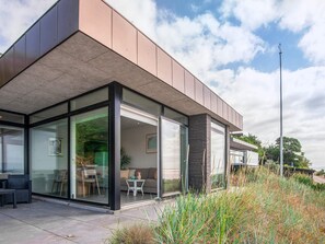 A modern building with large glass windows, a flat roof, and a clear sky. - 5 Star Holiday Home in Ega (Aarhus)