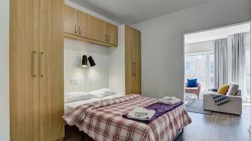 Una camera da letto con un letto, un armadio, una lampada da comodino e vista sull'esterno.