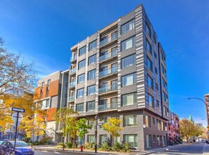 A multi-story building with a modern architectural design, featuring balconies and large windows. - The Downtown Zando (Montréal)