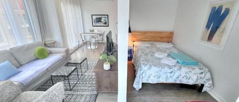 Habitación cuádruple Deluxe, vista a la ciudad | Escritorio, cortinas blackout y tabla de planchar con plancha
