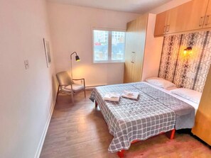 Une chambre à coucher avec un lit, une chaise, une fenêtre et une armoire.