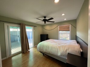Ein Schlafzimmer mit Bett, Deckenventilator und einem Fenster mit Jalousien.