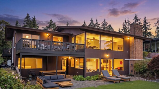 A modern two-story house with a balcony, outdoor seating, and a well-maintained garden. - Seattle Mid-century Reteat (Burien)