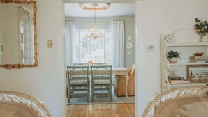 A room with a dining area, a chandelier, and a mirror. - French Tea House in Old Town+Private Hot Tub+Pet Friendly! (Albuquerque)