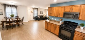 A modern kitchen with wooden cabinets, a stove, and a microwave. - 3-bedroom house in fabulous Tucson with cool AC for relaxing stay (Tucson)