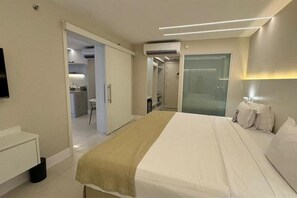 Une chambre d’hôtel équipée d’un lit, d’une table de chevet, d’une télévision et d’un appareil de climatisation.