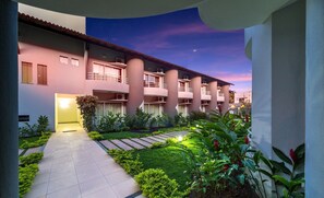 Un hotel con patio interior, varios balcones y cielo nocturno.