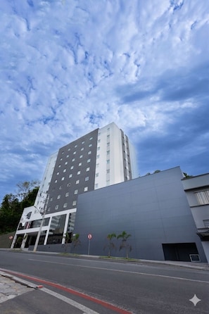 Ein modernes Gebäude mit flachem Dach, großen Fenstern und einer grauen Fassade.