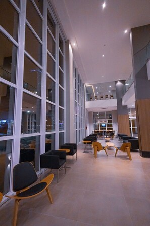 Un amplio espacio interior con ventanas grandes, diferentes opciones de asientos y un entrepiso.