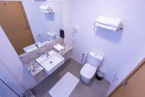 Une salle de bain équipée d’un lavabo, de toilettes et d’un porte-serviettes.