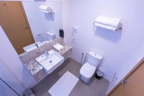 Une salle de bain équipée d’un lavabo, de toilettes et d’un porte-serviettes.