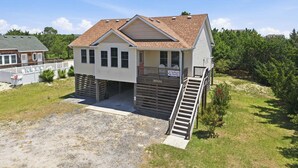 A two-story house with a covered porch and a small staircase leading to the entrance. - SO488 Salvo Sunrise -  Newly renovated oceanside home (Salvo)