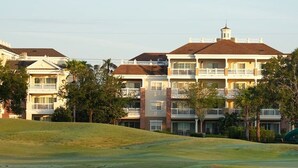 A multi-story hotel with balconies, a hilly landscape, and a golf course in the foreground. - 7/19-7/24; 3BR/2BA WorldMark Kissimmee Suite. Family Fun, Free Shuttle to Disney (Kissimmee)