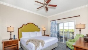 A hotel room with a bed, two bedside tables, a ceiling fan, a window with curtains, and a green chair. - 7/19-7/24; 3BR/2BA WorldMark Kissimmee Suite. Family Fun, Free Shuttle to Disney (Kissimmee)