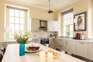 A kitchen with a marble countertop, white cabinets, and a large window. - The Courtyard House (Sleeps 4), Dorchester (Winterborne Came)