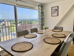 A dining area with a large table, four chairs, and a vase with flowers. - St Mary's Barn (Sleeps 4) - Stalbridge , Sherborne sleeps 4 guests  in 2 bedrooms (Stalbridge)
