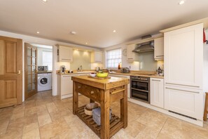 A modern kitchen with a wooden island, built-in appliances, and ample counter space. - The White House (Sleeps 4) -West Lulworth, Lulworth Cove,sleeps 4 guests  in 2 bedrooms (West Lulworth)