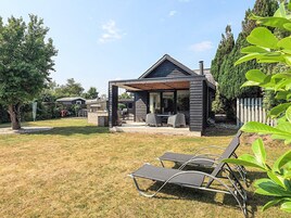 Un patio moderno al aire libre con una zona de estar cubierta y una piscina.