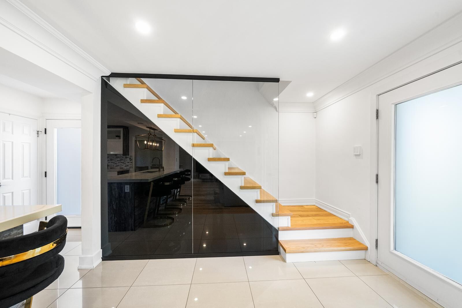 A modern interior with a staircase, a kitchen area, and a bar.