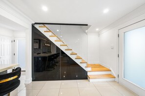 A modern interior with a staircase, a kitchen area, and a bar.