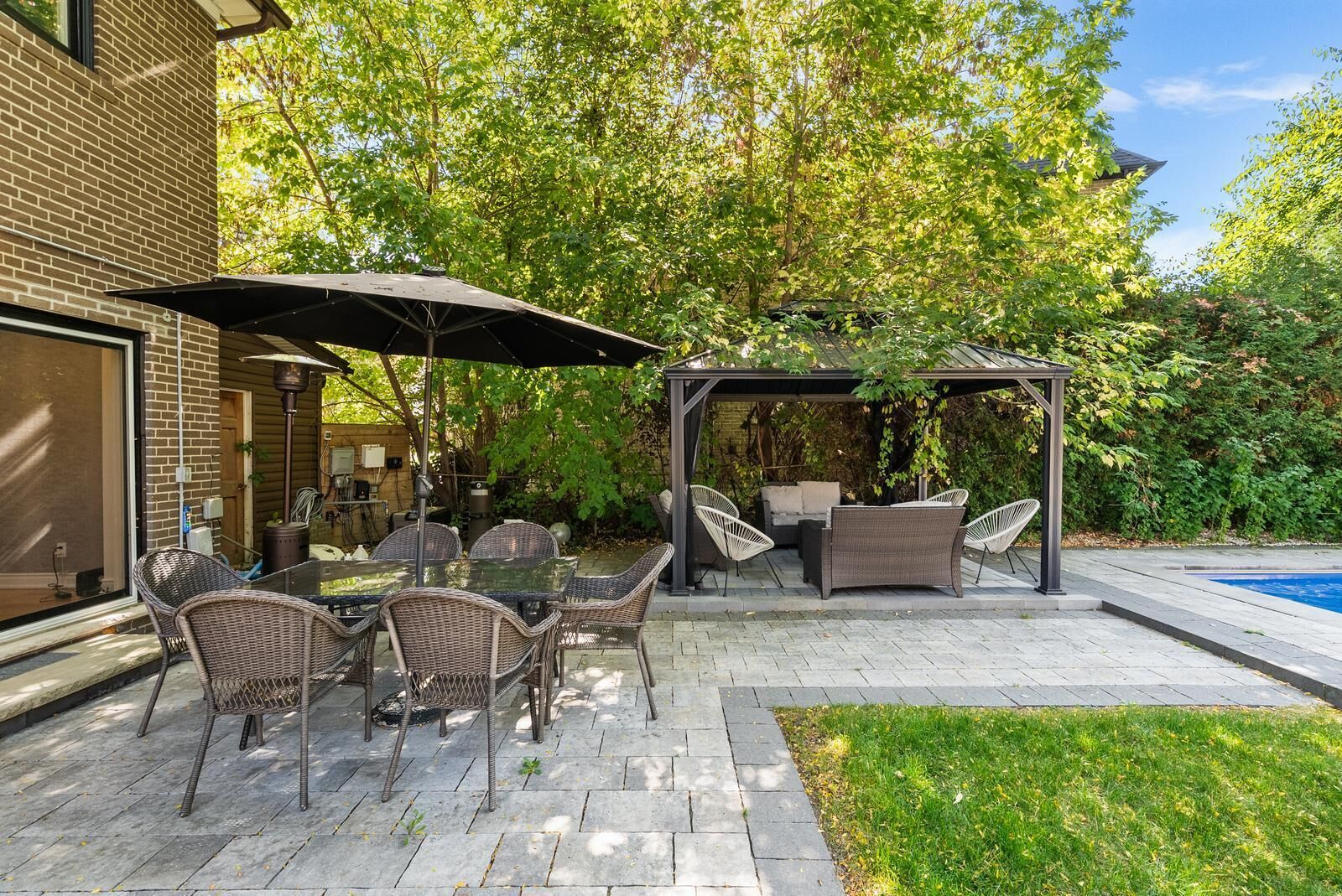 A patio with outdoor furniture, a pergola, and a swimming pool.