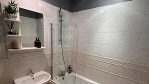 Een moderne badkamer met een bad, een wastafel en een douche.