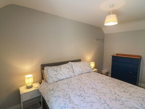 A bedroom with a bed, nightstands, a dresser, and a hanging lamp. - ABINA'S, family friendly, with a garden in Kenmare, County Kerry (Kenmare)