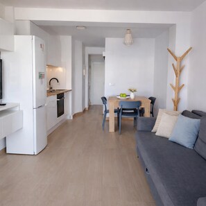 Ein modernes Wohnzimmer mit Küche, Essbereich und Sitzgelegenheit.